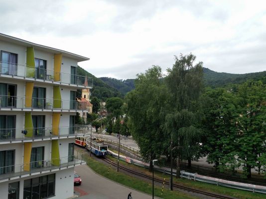 Interir apartmnu - pohad z balkna apartmnu na motorov vlak na zkokoajnej trati Trenianska Tepl-Trenianske Teplice. Vavo hotel Panorma.